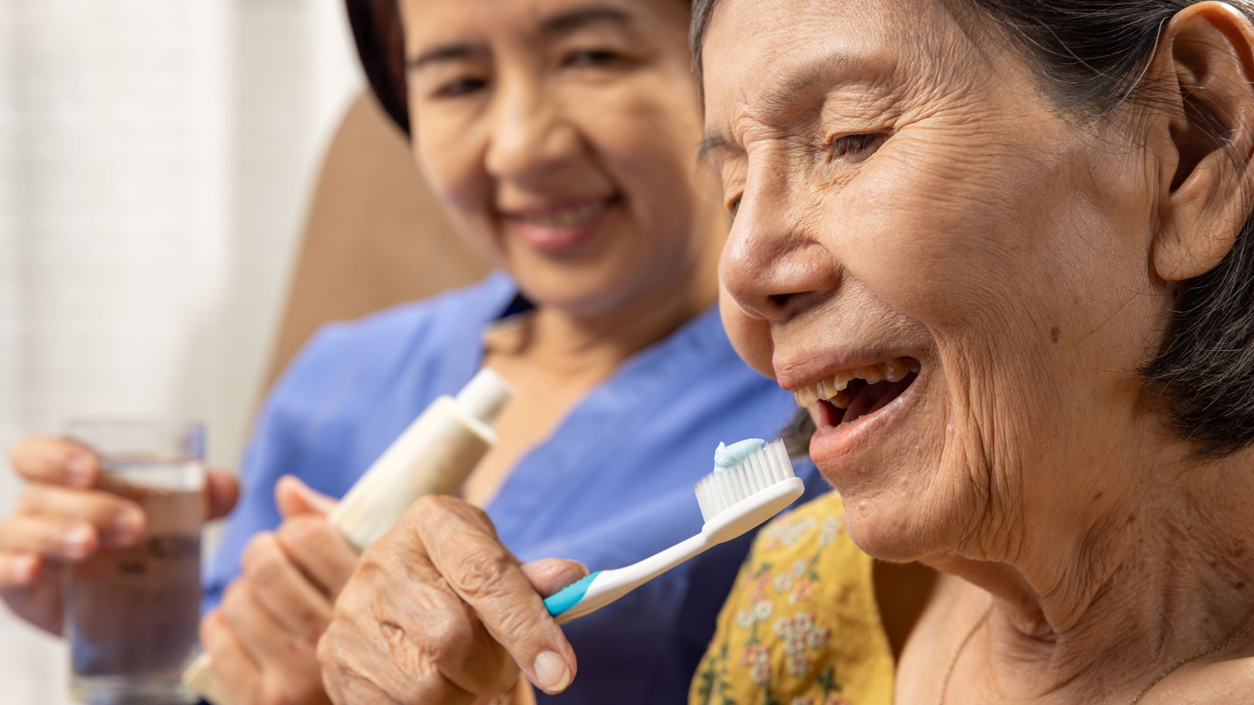 caregiver helping elderly parent with daily caregiver helping elderly parent with daily dental care routine