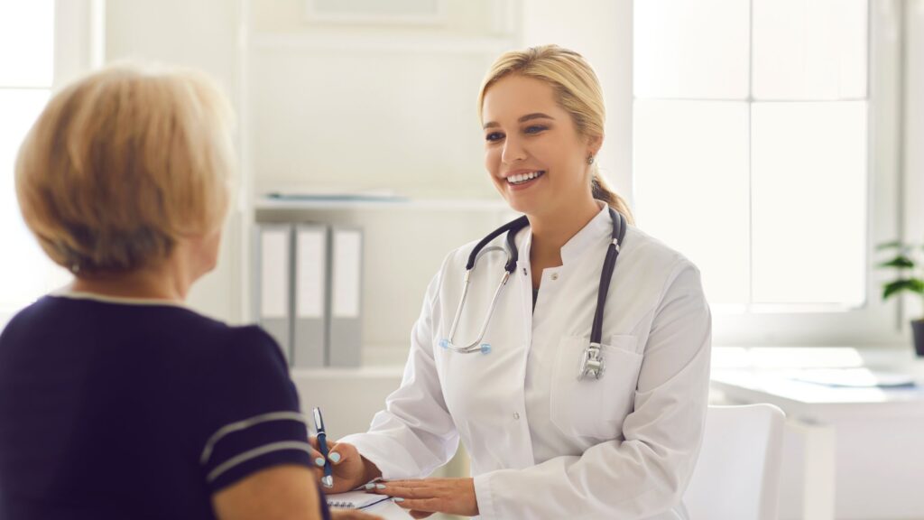 Elderly patient and caregiver meeting with geriatric dentist