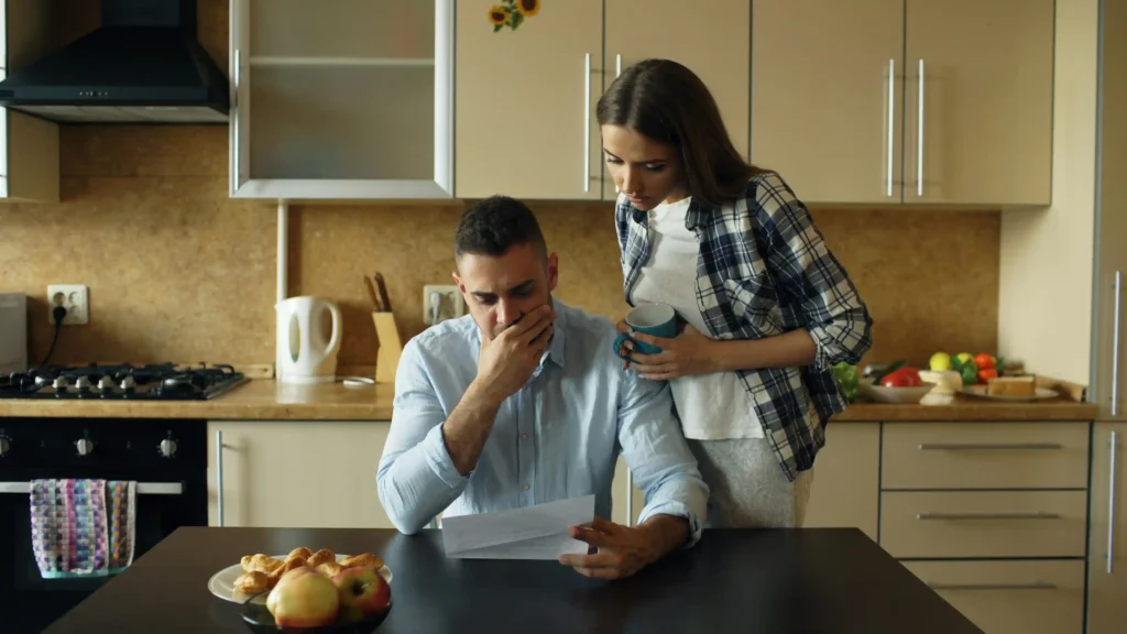 family reviewing in-home care costs and monthly budget at kitchen table
