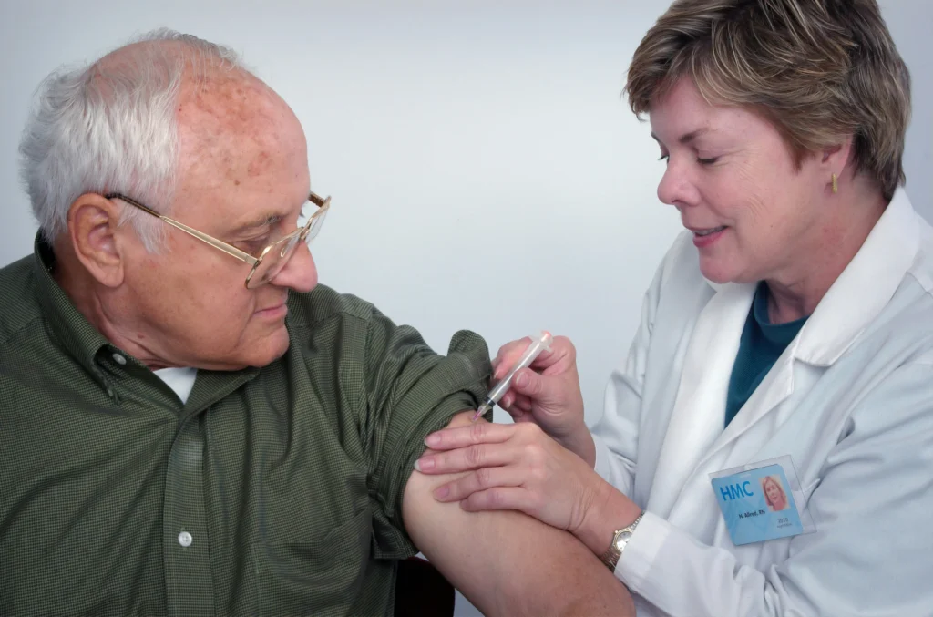 senior receiving a flu vaccine from a doctor to prevent respiratory infection
