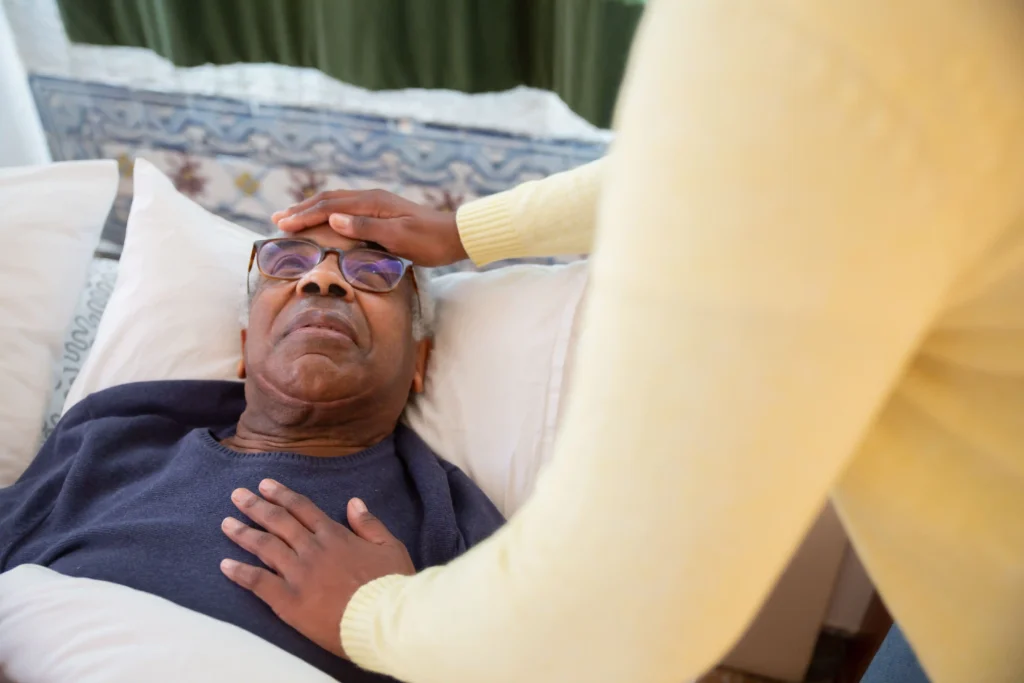 caregiver checking elderly parent's temperature during morning health routine