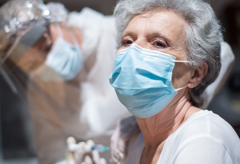 Elderly parent receiving pneumococcal vaccine from doctor