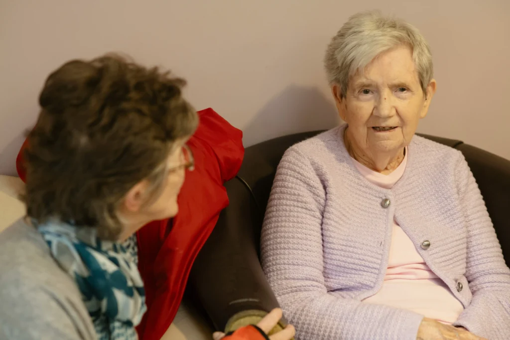 adult child having a warm conversation with senior parent with early-stage dementia