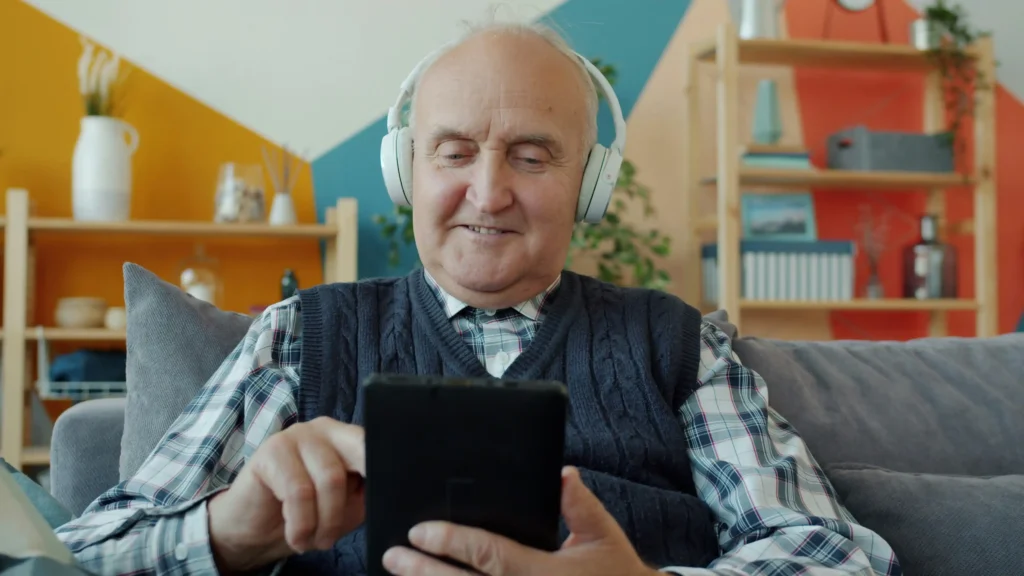 Elderly parent with dementia singing along to classic music with caregiver