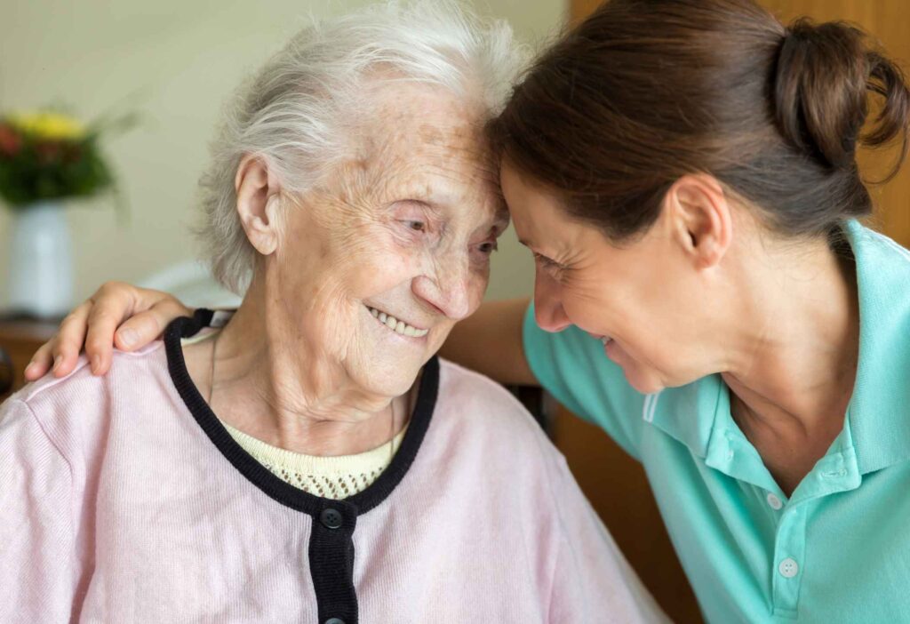 Caregiver providing gentle comfort to a parent in the final stage of dementia